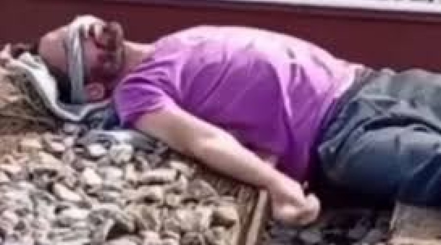 Homem deita em trilho e trem passa por cima dele em trend viral. Veja