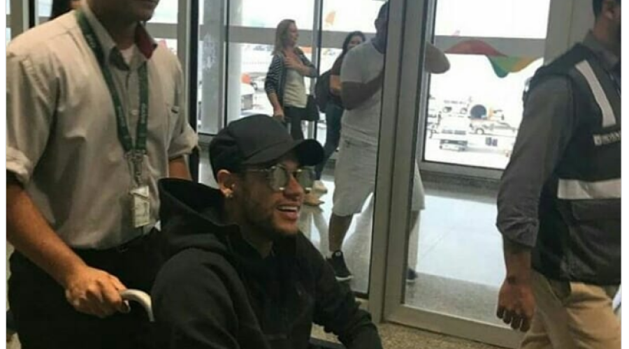 Neymar chega de cadeira de rodas; prazo para volta pode ser maior